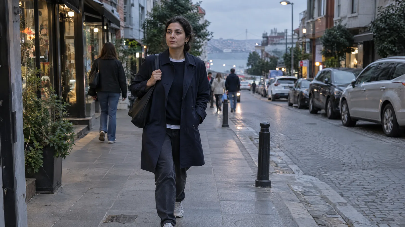 İş çıkışı şehir sokağında çantasıyla yürüyen otuzlu yaşlarda kadın